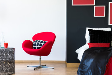 Multifunctional bedroom with red chair