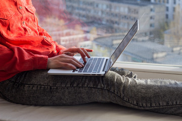 Woman work with laptop on window sill 
