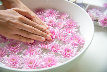 Fototapeta premium Spa treatment and product for female feet and manicure nails spa with pink flower, copy space, soft and select focus, Thailand. Healthy Concept.