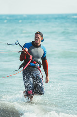 Portrait of handsome man kitesurfer in the beach.
