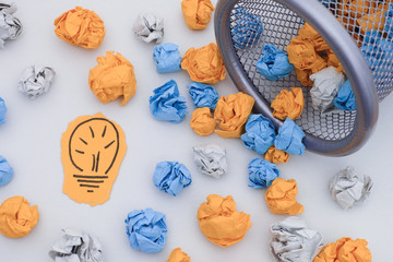 New Idea. Colorful crumpled paper balls rolling out of a trash can