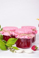 Homemade raspberry jam for breakfast and fresh raspberry on white wooden table