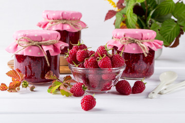 Homemade raspberry jam for breakfast and fresh raspberry on white wooden table
