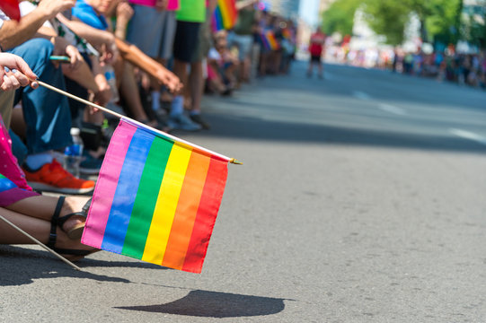 Gay rainbow flag at Montreal Gay Pride Parade 2017 with blurred spectators in the background