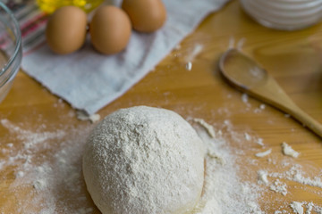 Dough, eggs and rolling pin on the kitchen table for cooking. Concept holiday and home comfort.