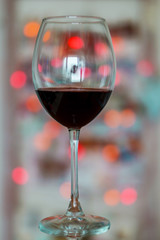 Close up, red wine glass on a bokeh background. Concept holiday.