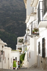 Frau säubert in einer Gasse von Capileira,  Spanien