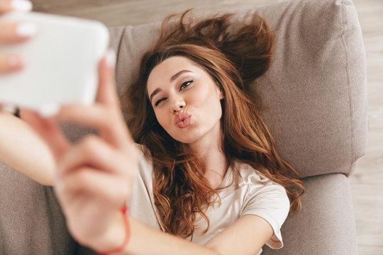 Cute young woman making selfie on smartphone