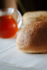 Fresh hot bread on white tablecloth at restaurant table.