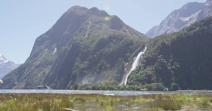 Cruise ship boat tour in New Zealand Milford Sound by Waterfall in Fiordland National Park, South Island. Lady Elizabeth Bowen Falls nature landscape scenery. Tourist destination, New Zealand