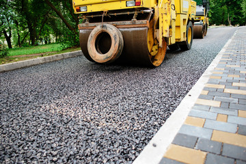 Carrying out repair works: asphalt roller stacking and pressing hot lay of asphalt. Machine...