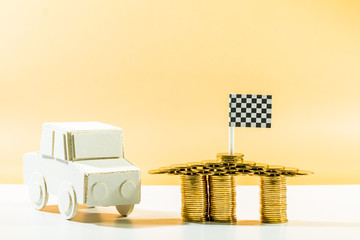 A car model and stacking gold coins and the checkered flag a symbol of victory and success embroidered on top for loans concept.