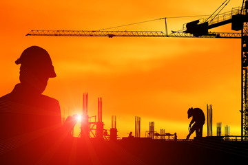 Silhouette construction engineer in the process of checking the construction site