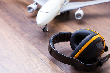 Ear protection on the wooden floor with airplane in back