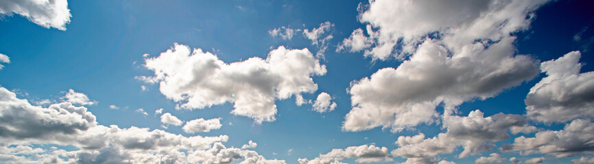 Naklejka na ściany i meble Panorama of the blue sky with white clouds