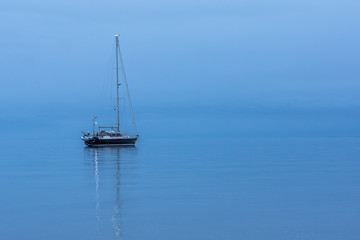 Fototapeta premium Sailing boat alone in the ocean durig blue hour. HDR-Photo