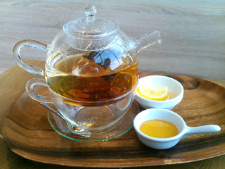 Green hot tea on a teapot on a wooden background.