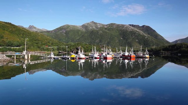 Picturesque fishing port in Henningsvaer on Lofoten islands, Norway with typical red wooden buildings and small fishing boats