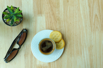 top view. espresso coffee in white cup with two pieces of cookies and sunglasses and mock up plant