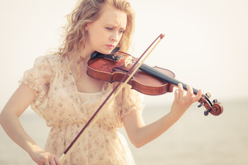 Woman playing violin on violin near beach