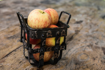 Fresh apples in old metal rusty distressed basket © Olga Kulakova
