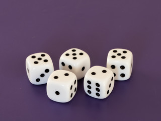 Five white dices lying on a table