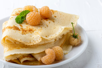 Homemade  crepes served with fresh yelllow raspberries