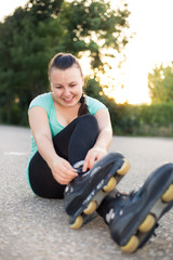 Woman is going roller skating. Putting on in-line skates. Close up. Sport lifestyle.
