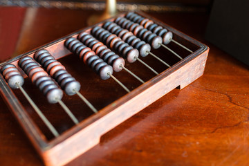 Vintage wooden abacus on a wooden table. The old interpretation of the modern calculator