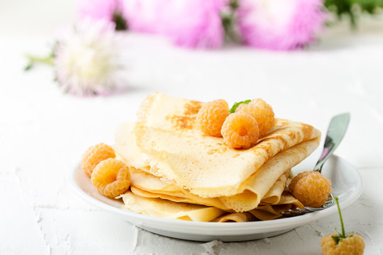 Homemade  crepes served with fresh yelllow raspberries