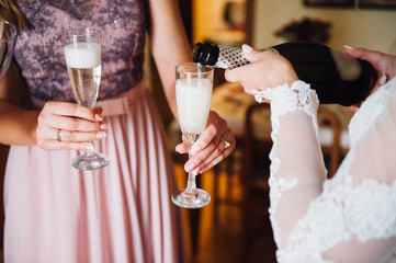 The bride and girlfriend drink champagne. Close-up