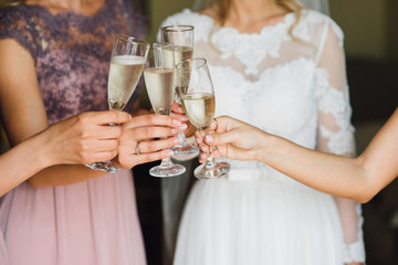 The bride and girlfriend drink champagne. Close-up
