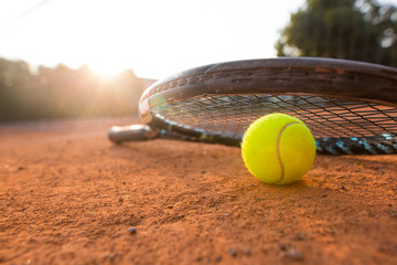 Close up view of tennis racket and balls on the clay tennis court, recreational sport