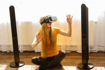 Girl wearing virtual reality goggles at home