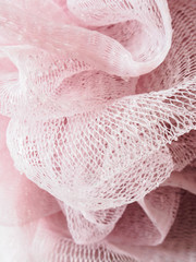 Pink plastic loofa hygine scrubber covered of water drops