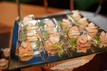 Little glass plates with shrimps and greenery