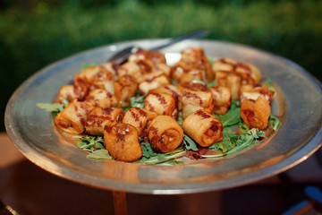 Tasty rolls and greenery served on steel dishes