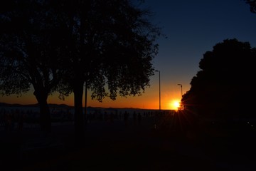 sunset over coast with walking people 