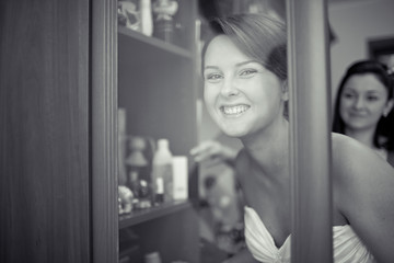 Bride looks at something in the wardrobe and smiles