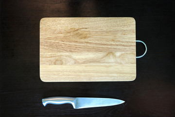 stainless  kitchen knife and wood cutting board