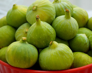 Green figs in red bowl