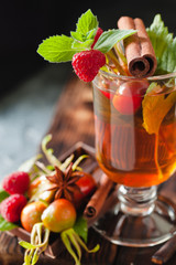 Rosehip tea in glass on black stone background