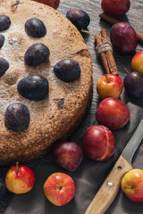 Pie with fruit. The cake is decorated with fresh plums and apples.