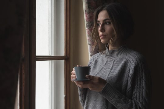 Close up of thoughtful woman having coffee while standing by