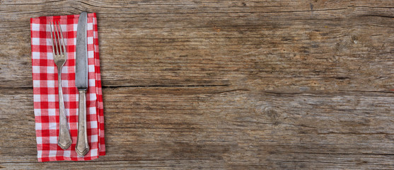 Obraz premium Cutlery and napkin on wooden background