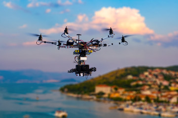 The drone with the professional cinema camera flying over the old town at the sunset. Trogir, Croatia. Blurred background.