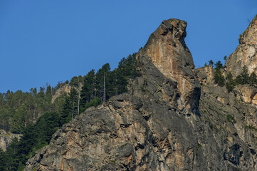 Mountain top of eagle's rock overgrown with coniferous forest and glade of Rila mountain, Bulgaria 