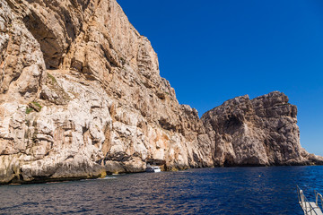 Fototapeta na wymiar Sardinia, Italy. The excursion boat enters the grotto of Neptune