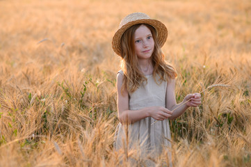 Beautiful child play a field of wheat