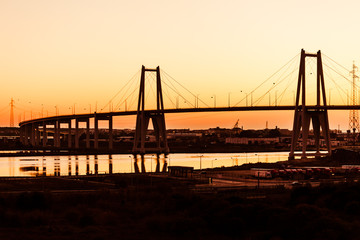 Silhouette of the suspension concrete bridge on a sunset